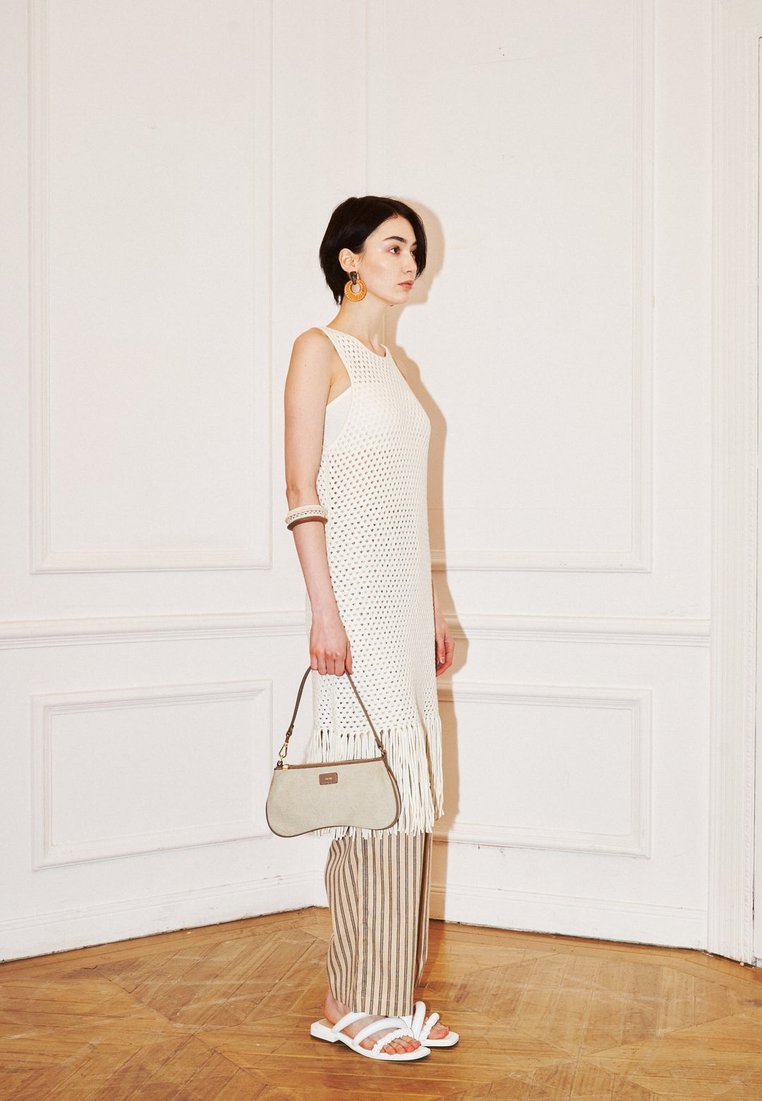 Sac bandoulière JW PEI Eva Beige Canvas porté en bandoulière par une femme, vu de profil gauche